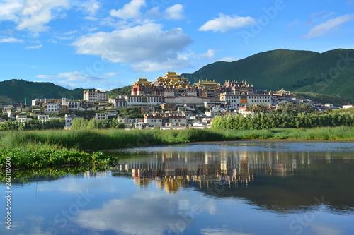 Beautiful view of the Ganden Sumtseling Temple reflecting in the water. Zhongdian (Shangri-La), China