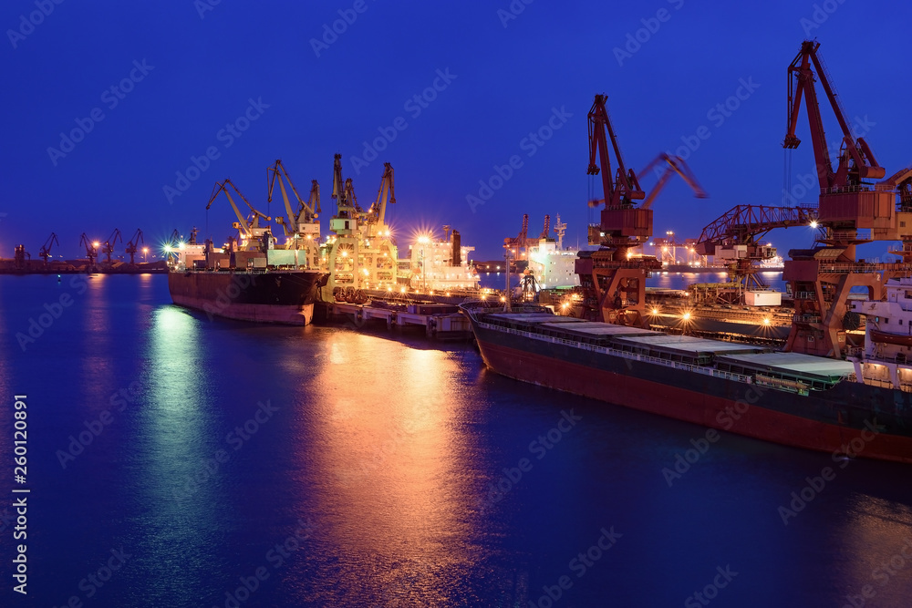 Cargo ship in port of Rizhao, China, inner harbor under deep blue twilight sky Cargo ship in port of Rizhao, China, inner harbor under deep blue twilight sky
