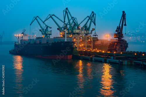 Cargo ship in port of Rizhao, China, inner harbor under deep blue twilight sky