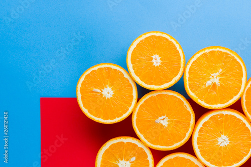 Cut halves of juicy orange on multicolored background. Orange fruit, citrus minimal concept. Creative summer food minimalistic background. Top view, copy space