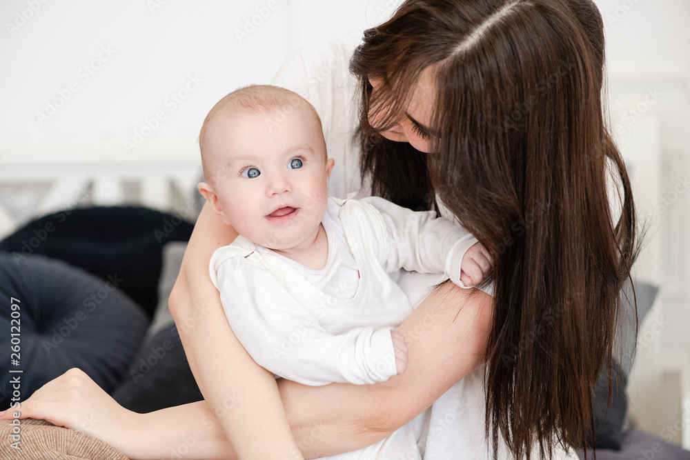Charming infant girl in mother arms indoors. Charming infant girl in mother arms indoors.
