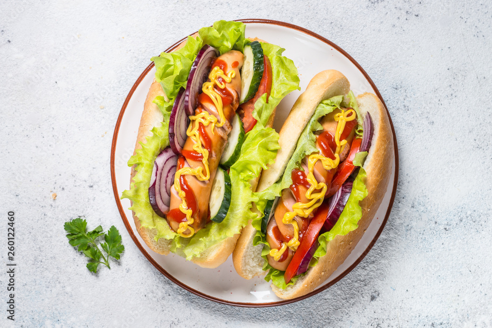Hot dog with fresh vegetables on white top view. Hot dog with fresh vegetables on white top view.