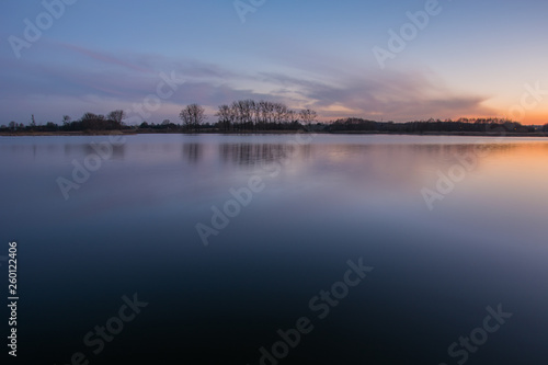 Calm lake and colorful clouds after sunset