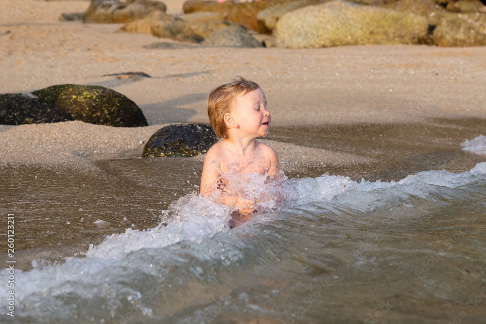 Little boy sitting on the beach in the water Little boy sitting on the beach in the water