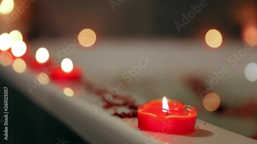 rose petals in water and a candle in the bathroom. romantic evening for people in love. Valentine's Day.