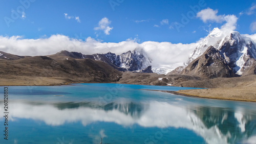 Beautiful landscape of vast sky mountain and lake with reflection of cloud in clean greenish water © Souvik