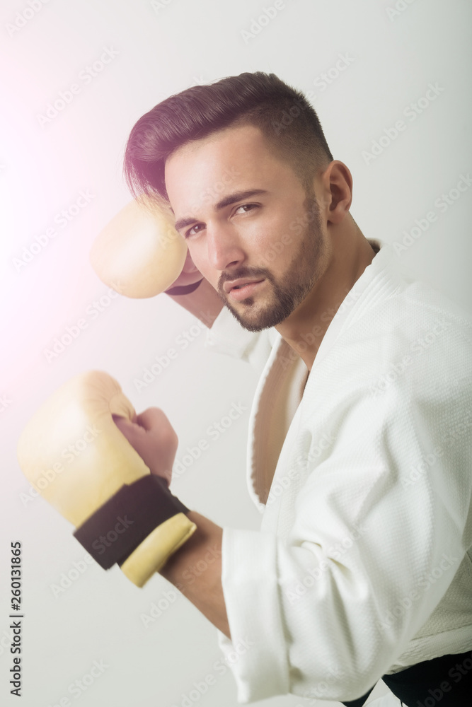 Trendy hairstyle, beard and passionate look in modern combat art.  Passionate look of sexy man. Vintage photo of handsome sportsman. Man  groomed photo portrait. Fighting in karate, posture of attack Stock Photo |