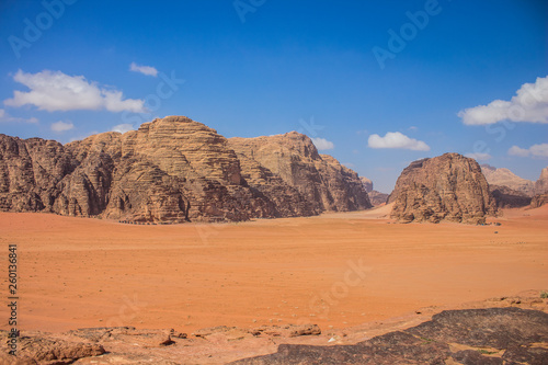 picturesque desert panorama scenic landscape wilderness nature environment with big dune yellow valley foreground and sand stone mountain ridge background summer bright vivid colorful dry weather time