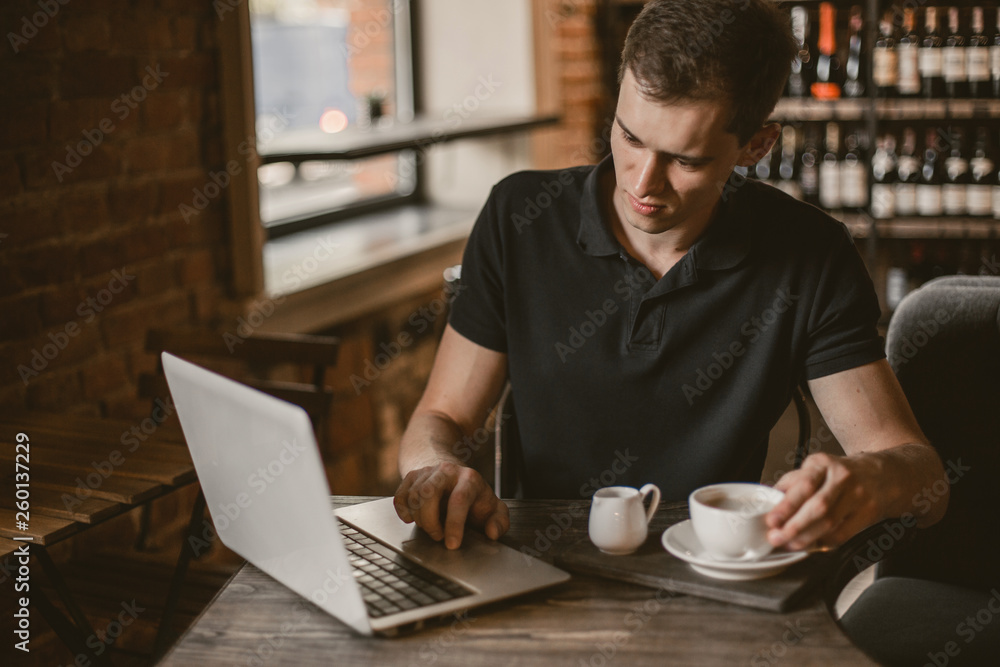 Businessman working on a laptop in a cafe. Businessman working on a laptop in a cafe.