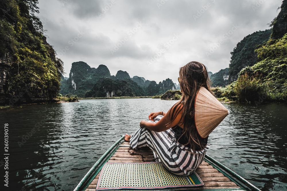 A woman on a river boat in Ninh Binh. Mountains of northern Vietnam.