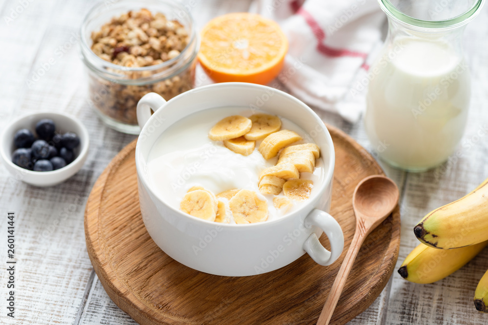 Natural Yogurt With Banana In Bowl. Healthy breakfast, clean eating concept Natural Yogurt With Banana In Bowl. Healthy breakfast, clean eating concept