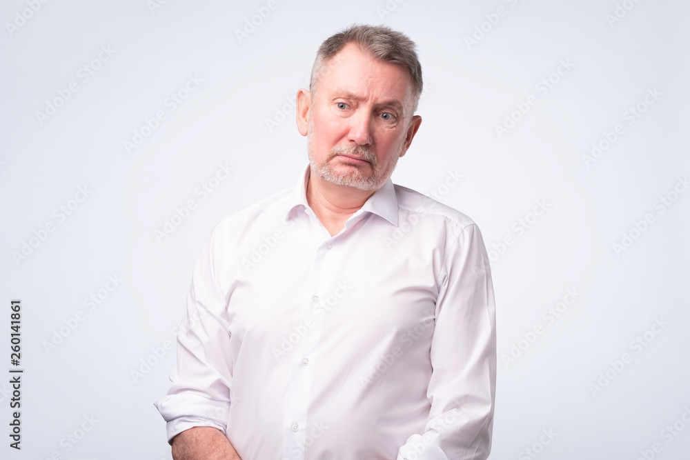 Old senior man in white shirt with serious and sad expression. Old senior man in white shirt with serious and sad expression.