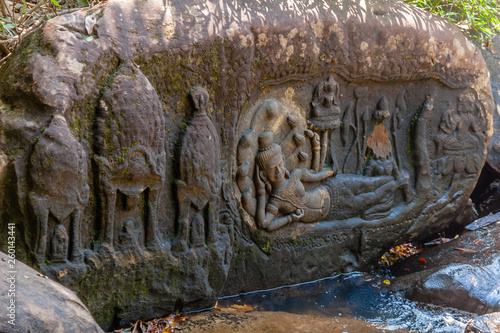 Lord Vishnu in a reclining repose lying on the serpent god Ananta, with Goddess Lakshmi at his feet and Lord Brahma on a lotus petal, in Kbal Spean River bank photo