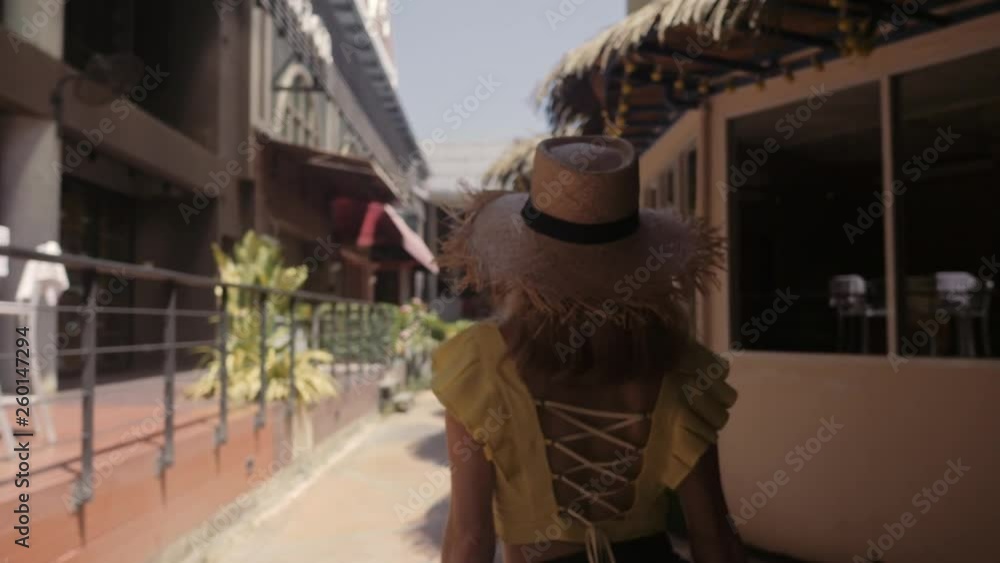 Beautiful woman in straw hat walks the street. Playing to camera. Beautiful woman in straw hat walks the street. Playing to camera.