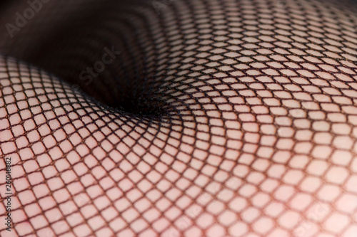 Close up of female legs in black fishnet stockings photo