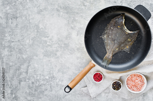 Raw flounder in the pan. Gray background, top view, space for text.