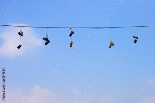 Old shoes hang on wire © sasaperic