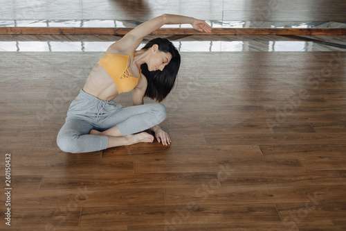 young attractive girl on a wooden floor doing yoga, stretching and relaxing