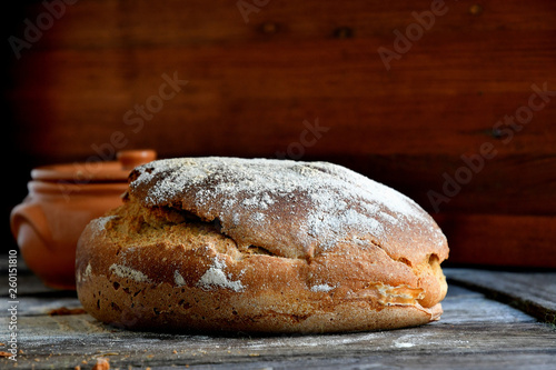 Homemade rustic bread on a wooden background.