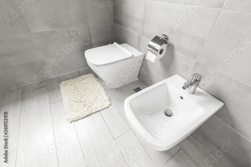 White ceramic bidet and toilet at luxury bathroom interior photo