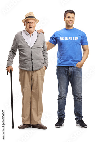 Young volunteer helping an elderly man with a cane