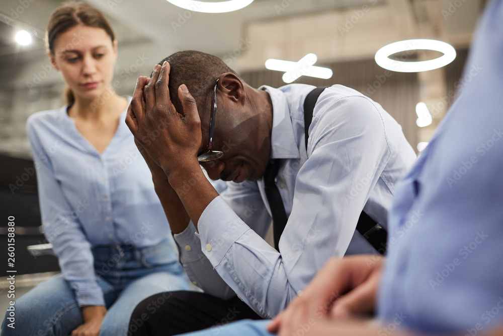 Side view portrait of depressed African-American man sharing troubles with support group in therapy session, copy space Side view portrait of depressed African-American man sharing troubles with support group in therapy session, copy space