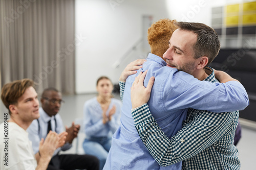 Side view  portrait of mixed race woman hugging psychologist during therapy session in support group, copy space photo