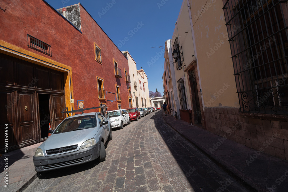 Cars line a cobblestone backstreet in Queretaro Mexico