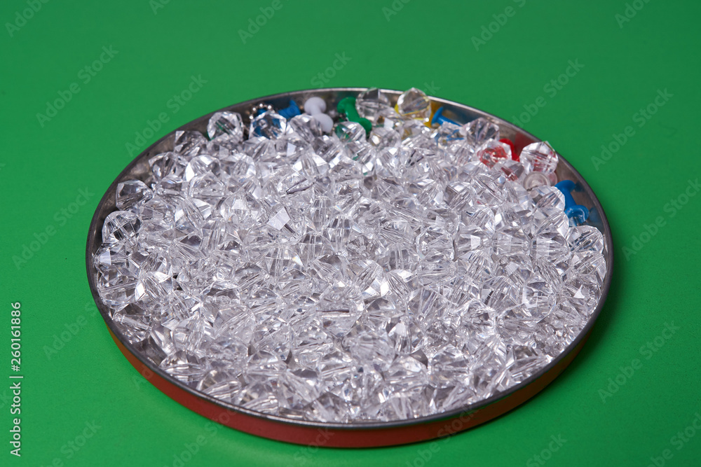 crystal rhinestones on a small tin plate. Small stones of glass. Bijouterie. Artificial jewelry made of glass and plastic. Rhinestones for decor crystal rhinestones on a small tin plate. Small stones of glass. Bijouterie. Artificial jewelry made of glass and plastic. Rhinestones for decor