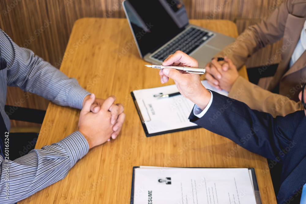 young man explaining about his profile to business managers sitting in job Interview. listen to candidate answers Hiring employee, nervously clutched scolded by boss.