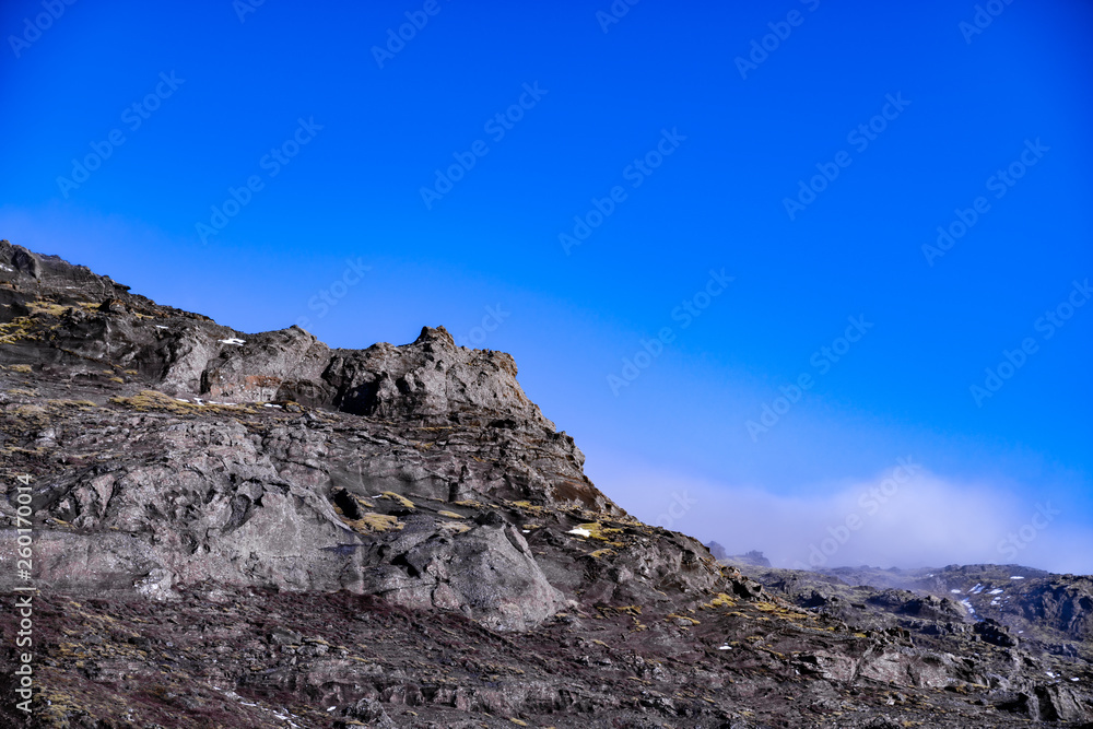 Close up of a mountain peak with clouds coming in over the mountain