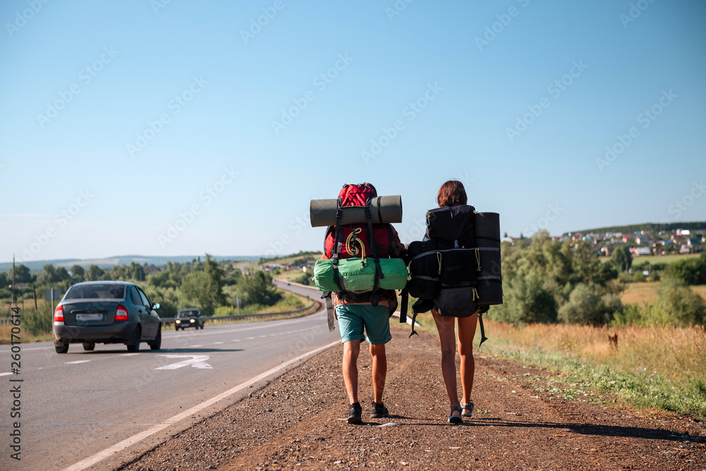 Obraz premium Travel man hitchhiking. Backpacker on road