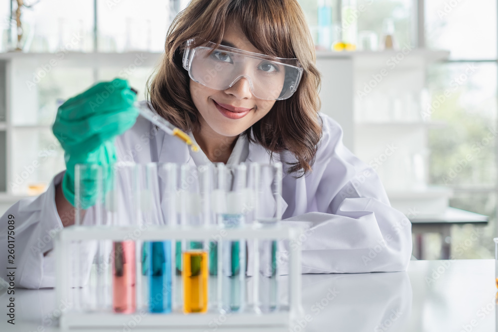 A young Asian woman scientist working in laboratory with test tube microscope and solutions. A young Asian woman scientist working in laboratory with test tube microscope and solutions.