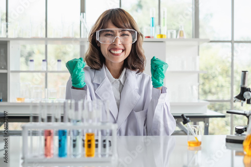 Bilde på lerret A young Asian woman scientist working in laboratory with test tube microscope and solutions looking excited and happy