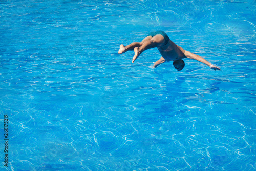 a man jumps into the pool. Swimmer in the water