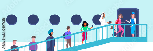 stewardess welcoming mix race passengers at aircraft ladder flight attendant in uniform near airplane door welcome on board to travel or vacation trip full length flat horizontal