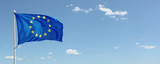 EU flag waving against blue sky with clouds. Copy space
