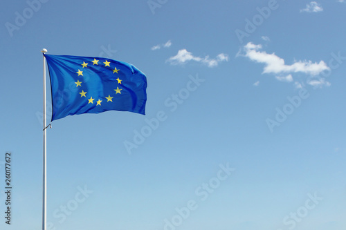 European Union flag waving in the air on blue sky background. Copy space