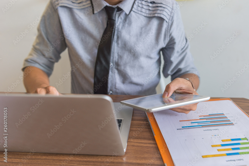 Businessman using laptop and tablet in the office Businessman using laptop and tablet in the office