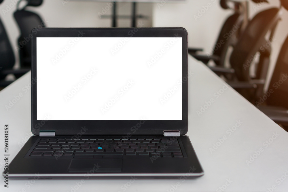 Front view of the laptop with blank white screen on the work table in meeting room, Mock up selective focus with clipping path.