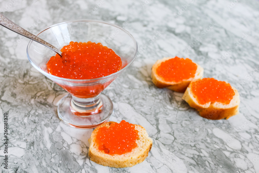 Top view of Sandwiches with red caviar on White marble background .Free space for text. Black caviar. Luxurious culinary delicacy. Close-up salmon caviar. Seafood. Red caviar close-up background. Top view of Sandwiches with red caviar on White marble background .Free space for text. Black caviar. Luxurious culinary delicacy. Close-up salmon caviar. Seafood. Red caviar close-up background.
