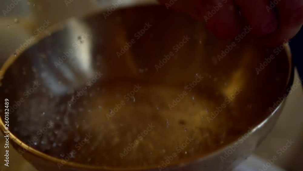 bronze tibetan bowl with water for healing by sound, vibrating and splashes are flying up bronze tibetan bowl with water for healing by sound, vibrating and splashes are flying up