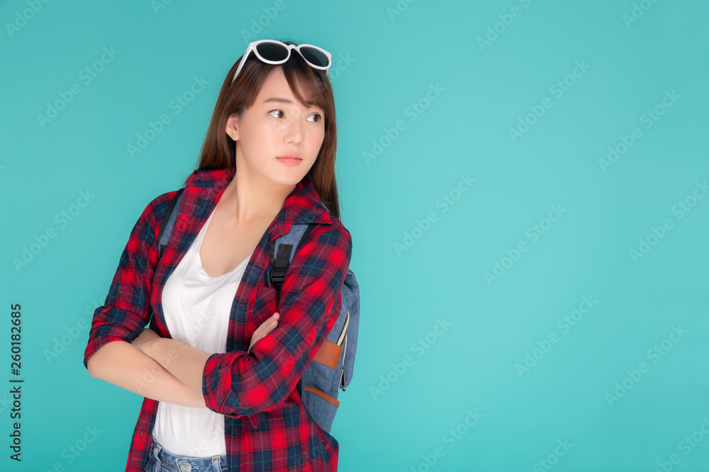 Fototapeta premium Beautiful portrait young asian woman wear sunglasses on head smile expression confident enjoy summer holiday isolated blue background, model girl fashion having backpack, travel concept.