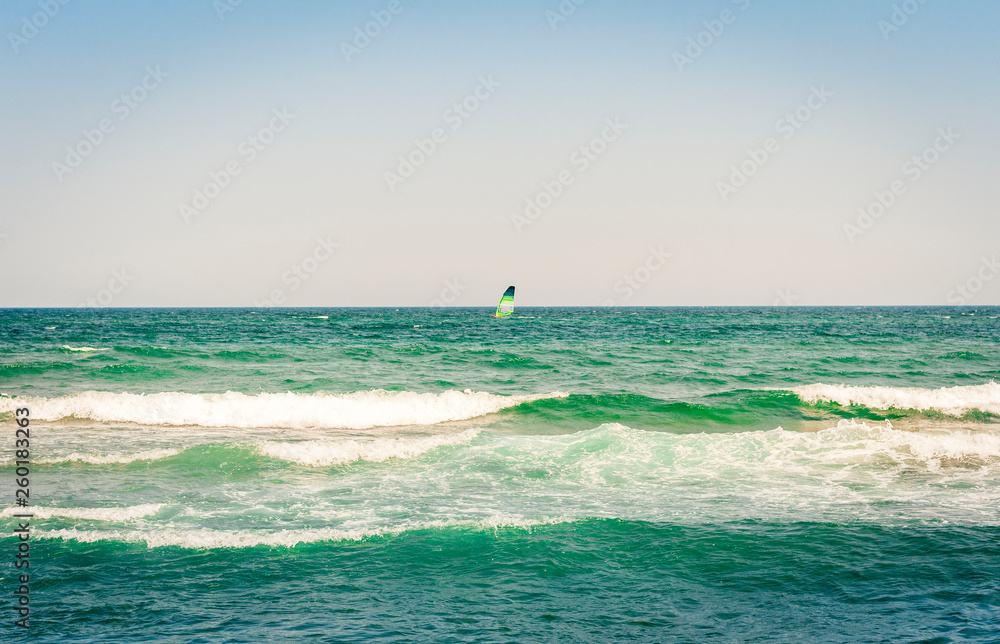 View from the beach of Catania, Sicily, Italy, Lido Cled with the green windsurf board in the sea.
