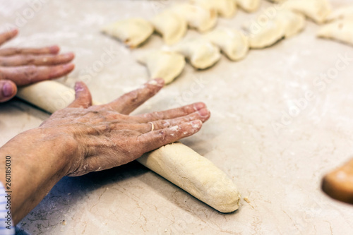 Female hands kneading making dough for dumplings .