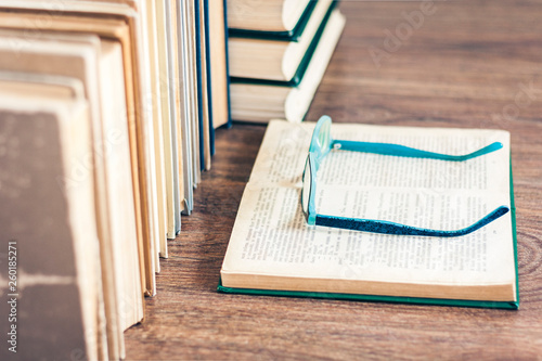 Stack of books, pencils, open book, glasses, background for education learning concept. © Inna
