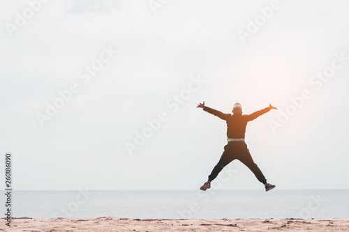 Happy man jumping at tropical sand beach background. Freedom feel good and summer vacation concept.