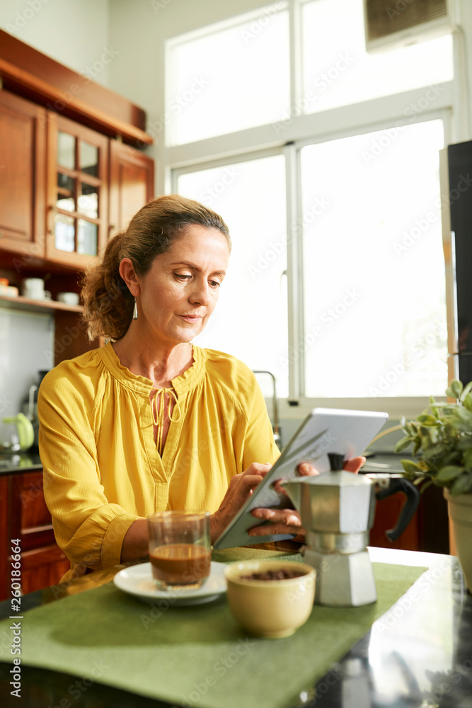 Middle-aged woman reading e-book