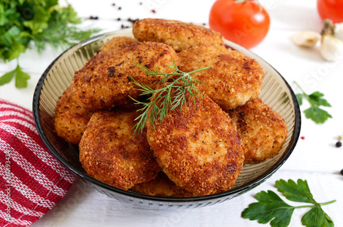 Juicy homemade cutlets (beef, pork, chicken) on a white wooden background.