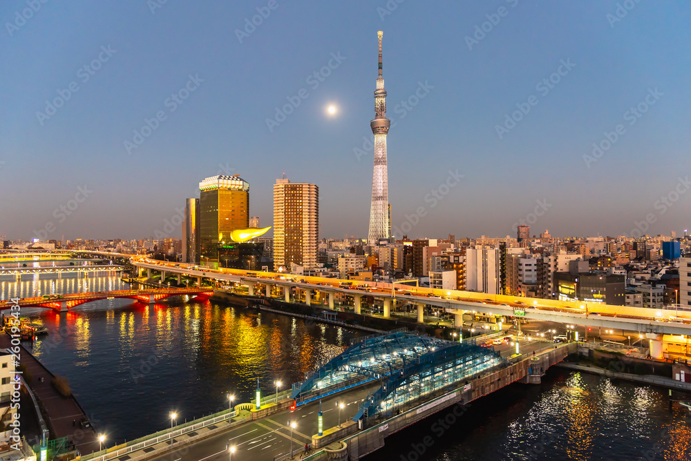 Tokyo Skytree and Sumida river in sunset sky with full moon.